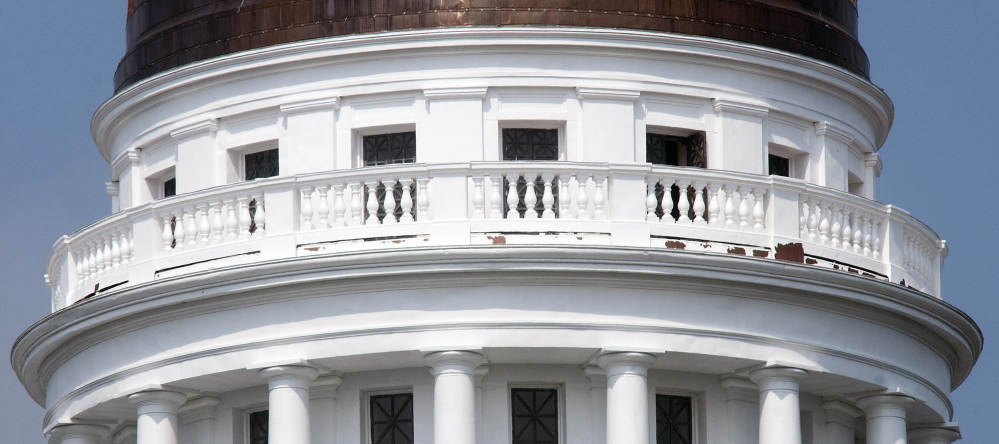 Peeling paint on the pillars around the State House dome in Augusta can be seen Wednesday.