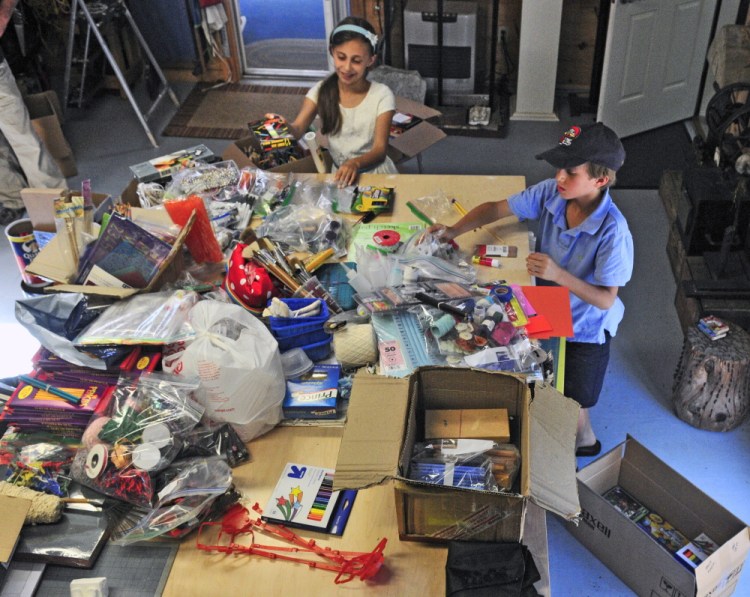 Ten-year-old twins Noah, left, and Ava Katz pose recently with the art supplies they collected and plan to donate to the Crow Indian Reservation in Montana.