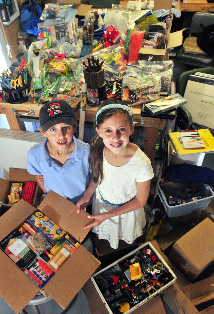 Ten-year-old twins Noah, left, and Ava Katz pose recently with the art supplies they collected and plan to donate to the Crow Indian Reservation in Montana.