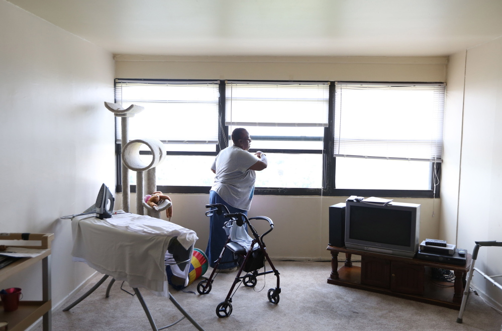 Renita Freeman opens a window in her Chicago apartment. She can walk in short bursts but needs a wheelchair when she leaves her building. “I’m not a stay-in-the-house kind of girl,” Freeman said. “I like to get out, smell the roses.”