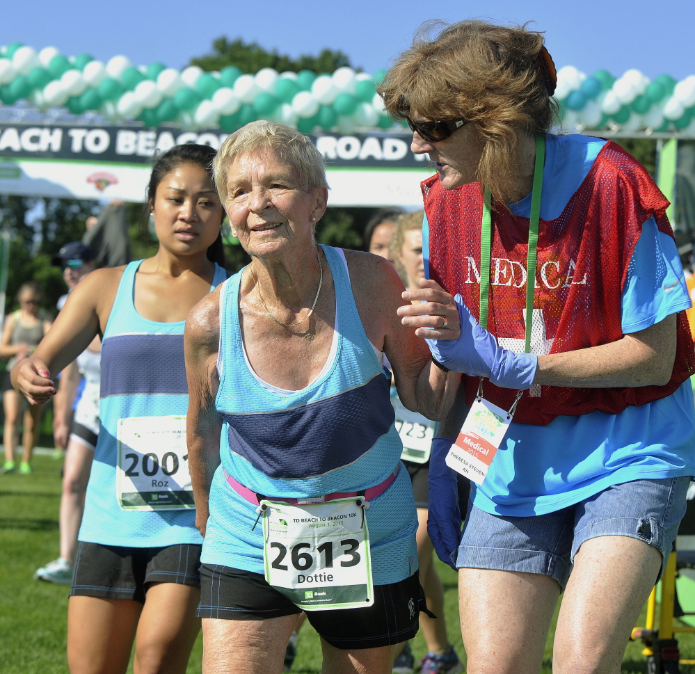 Dottie Gray, 90, from Kirkwood, Missouri, gets a little help from staff after completing her 15th Beach to Beacon race.