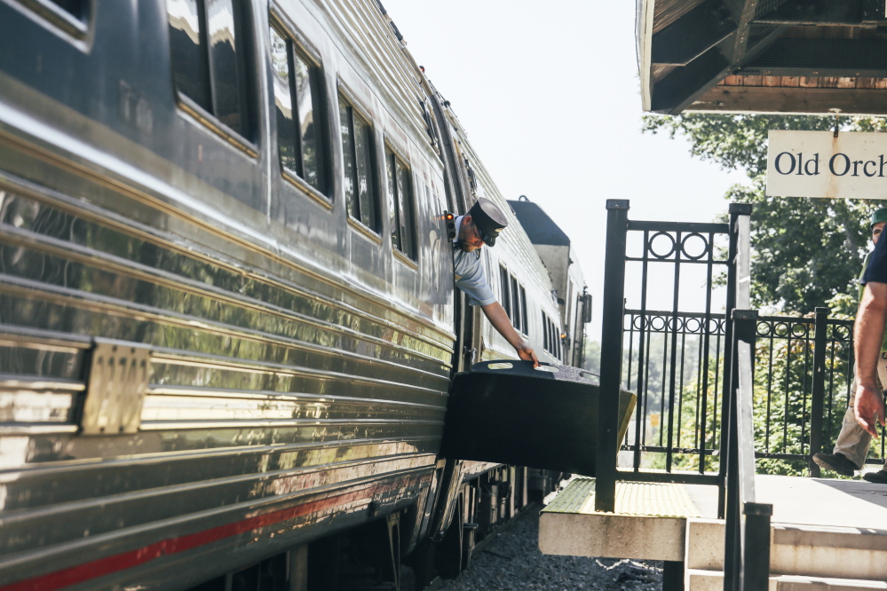 An Amtrak employee lowers the ramp of the Downeaster to the platform of the Old Orchard Beach station last Tuesday. The Northern New England Passenger Rail Authority, which operates the Downeaster,  has hopes of re-earning passengers’ trust after 16 months of stunning unreliability.