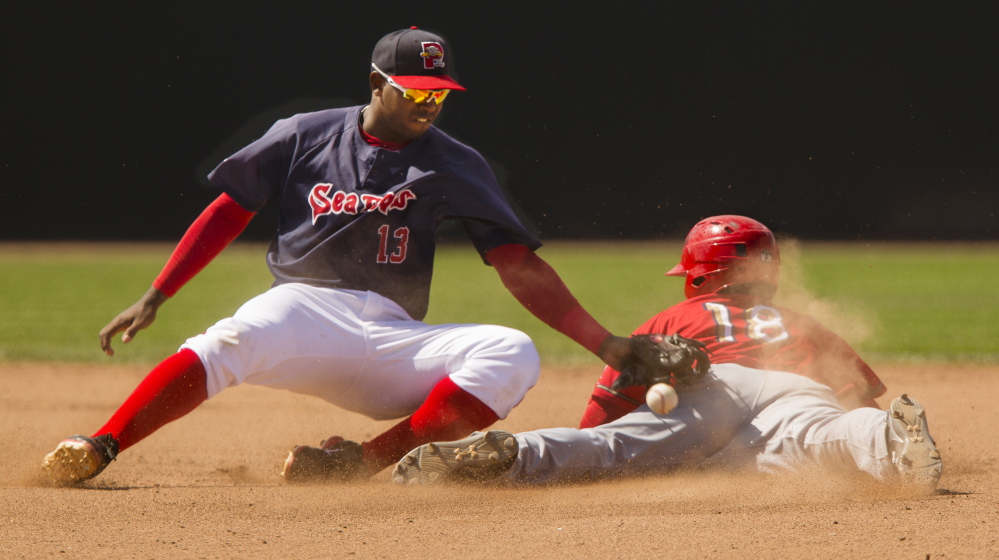 Sea Dogs shortstop Oscar Tejeda can’t handle the throw cleanly as Wilmer Difo of the Harrisburg Senators slides safely into second for one of his four stolen bases Sunday at Hadlock Field. Difo went 5 for 7 with a walk, scored three runs and drove in two for Harrisburg, which won 16-12 in 11 innings.