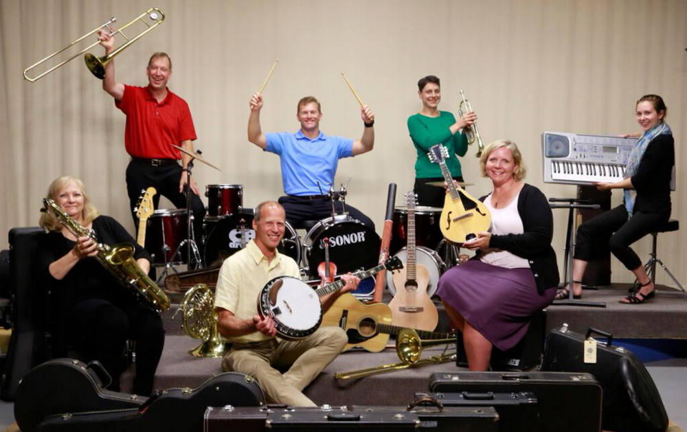 Members of the Maine Public Broadcasting Network staff show some of the musical instruments that were collected to be refurbished and distributed to needy young musicians.