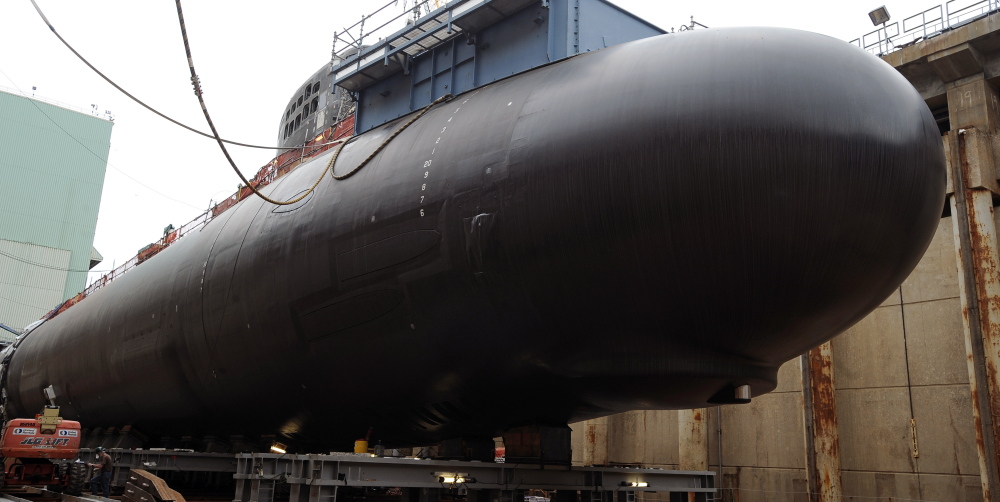 Shipyard workers at General Dynamics Electric Boat prepare the submarine Illinois for float-off in Groton, Conn. The Navy is using a new painting process and dozens of other innovations aimed at reducing the maintenance needs for attack submarines.