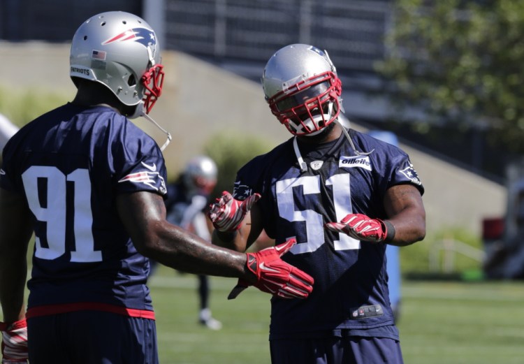 New England Patriots middle linebacker Jerod Mayo (51) talks with outside linebacker Jamie Collins (91) during training camp last summer.