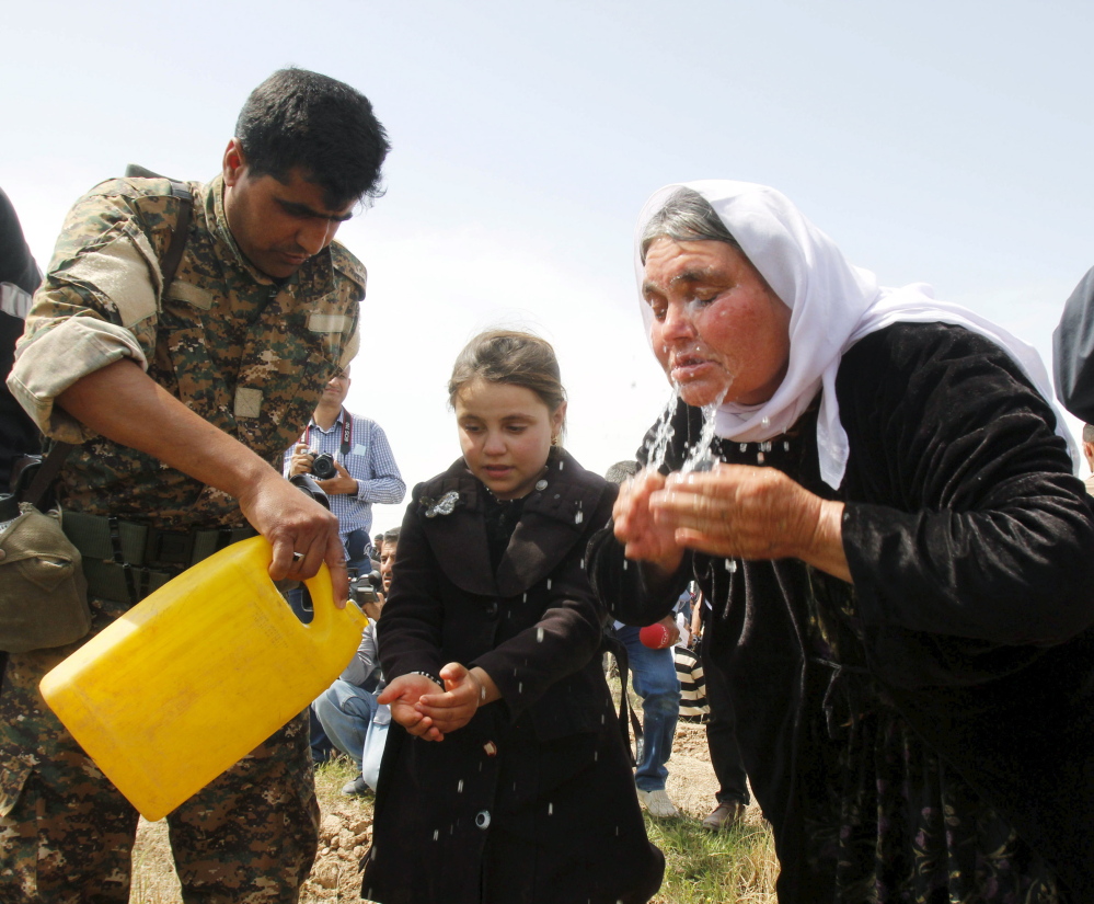 A member of the Kurdish Peshmerga helps out a woman and girl who were rescued from the Islamic State earlier this year near Kirkuk, Iraq. The U.N. says the Islamic State has been selling children like commodities.