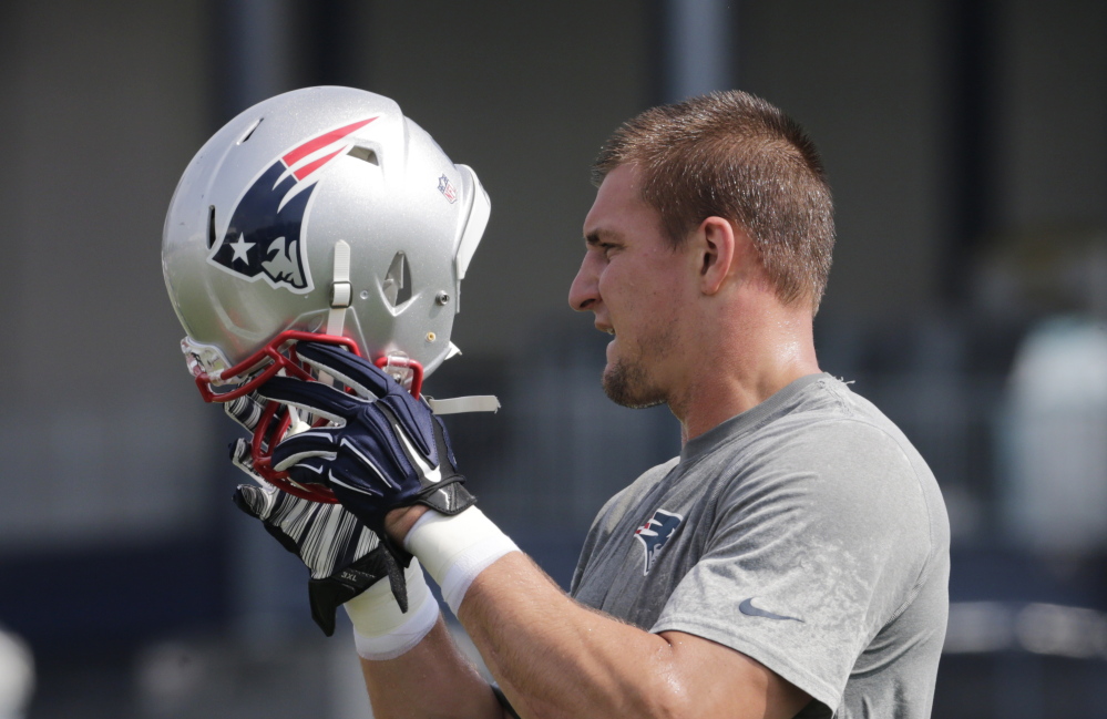 New England Patriots tight end Rob Gronkowski puts on his helmet during an NFL football training camp in Foxborough, Mass., on Thursday.
The Associated Press