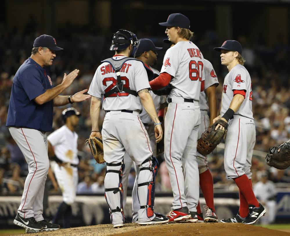 Boston Red Sox manager John Farrell applauds starting pitcher Henry Owens (60) as he removes Owens from Tuesday night’s game against the New York Yankees. Owens pitched into the sixth inning against New York in his major league debut.