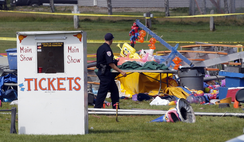 Investigators inspect the site Tuesday where a tent collapsed a day earlier during a Walker International Events circus at the Lancaster Fairgrounds in Lancaster, N.H. A Vermont father and his 8-year-old daughter were killed and more than 50 people were injured.