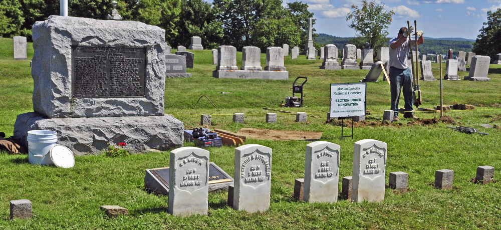Kevin Miller straightens a row of 4-by-4-inch granite markers Wednesday in one of the soldiers’ lots at Mount Pleasant Cemetery in Augusta.