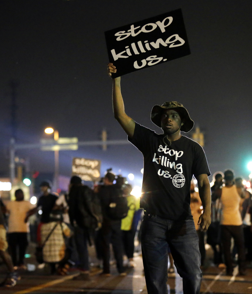 Protesters demonstrate in Ferguson, Mo., on Aug. 18, 2014. Recently released polls show that more white Americans believe blacks are treated less fairly than others by law enforcement officials.