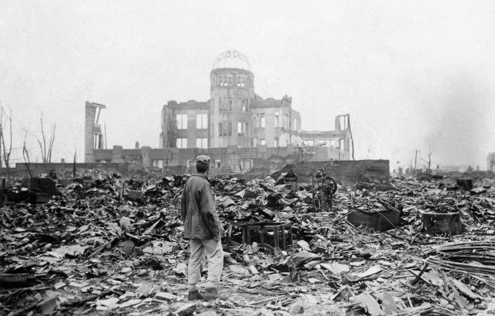 On Sept. 8, 1945, an allied correspondent stands in the rubble of Hiroshima, Japan. The building in the backgound is preserved as the Atomic Bomb Dome. Hiroshima was bombed on Aug. 6, 1945. Nagasaki was bombed three days later.