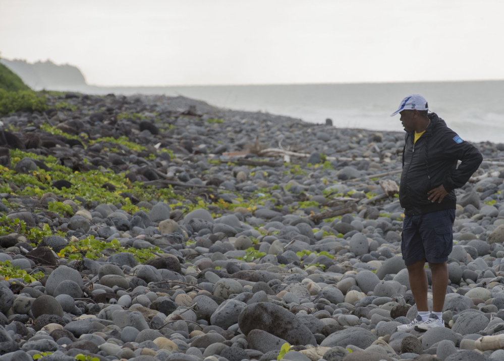 An unidentified man walks on Reunion’s Saint-Andre beach, as the search for more debris from the missing Malaysian Airlines Flight 370 continues Thursday.