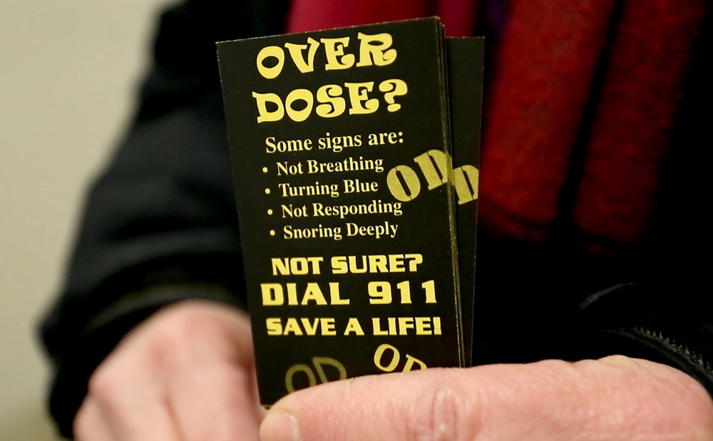 Ronni Katz of the city’s Overdose Prevention Project holds cards she hands out urging people to call 911 if there is a suspected overdose. At least 14 people overdosed on opiates in one 24-hour period last weekend in Portland. In a typical 24-hour period, five or six overdoses of all types – including non-opiates – are reported.