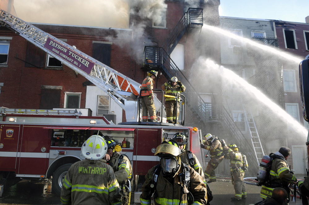 Firefighters on July 16 apply water to one of the buildings on Water Street in Gardiner that sustained extensive fire damage.