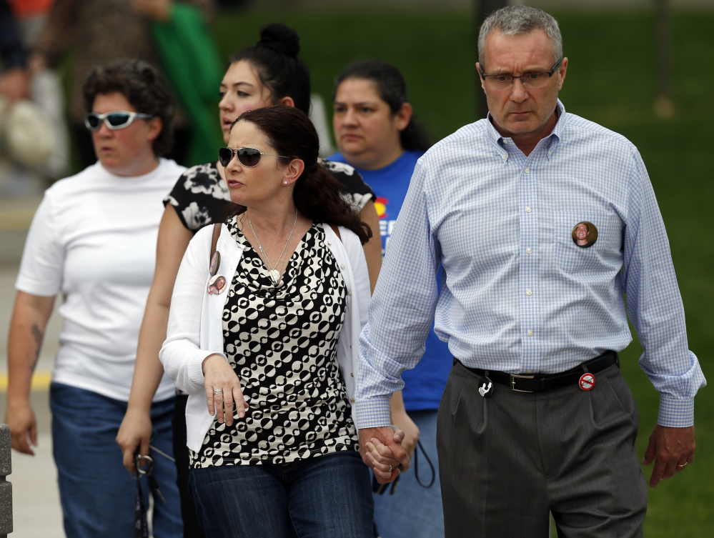 Tom Teves, right, and his wife, Caren, who lost their son, Alex, in the massacre in Aurora, Colo., in July 2012, leave the Arapahoe County Courthouse on Friday after jurors disagreed on whether James Holmes should get the death penalty.