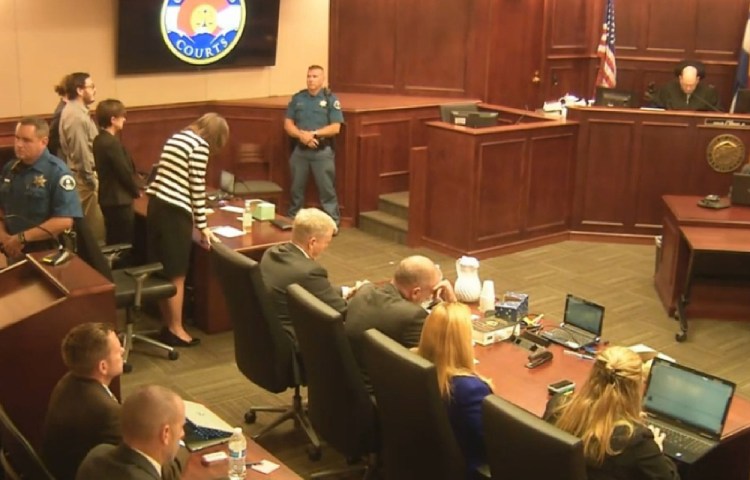 In this image made from Colorado Judicial Department video, Defense Attorney Tamara Brady, at left in stripped suit, leans into the defense table as Judge Carlos A. Samour Jr. reads the jury’s sentencing verdict Friday in the Colorado theater shooting trial. James Holmes, top left in tan shirt, will be sentenced to life in prison without parole because the jury could not agree that he should get the death penalty.