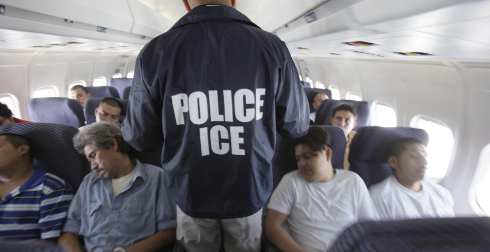 A federal Immigration and Customs Enforcement agent walks among shackled Mexican immigrants being deported in 2010. 
