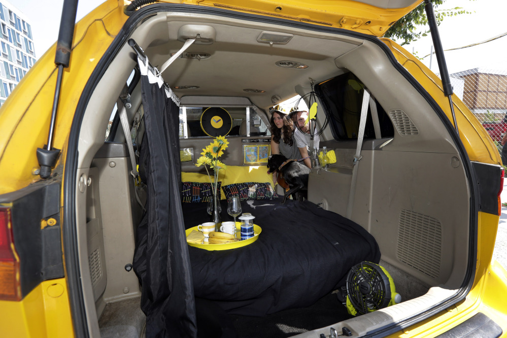 Airbnb renters Michael and Tabitha Akins and their dog check their accommodations in a decommissioned 2002 Honda Odyssey yellow taxi, in the Queens borough of New York. While parked vehicles make up only a fraction of the thousands of Airbnb listings in New York City, they provide an option for adventurous, budget-minded visitors seeking a place for far less than the $200-and-up most hotels charge. 
The Associated Press