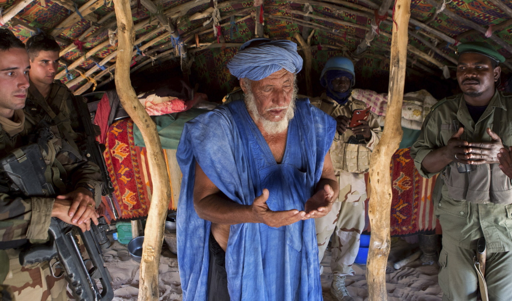 A village chief prays in 2014 after meeting with French soldiers north of Timbuktu, an area where Islamic extremists are now threatening the civilian population.
