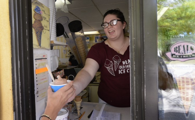 Caley Presby serves customers at Beals Ice Cream on Veranda Street in Portland. Presby, a senior at the University of Southern Maine, has had to rethink dental school because of the student-loan debt she would incur.