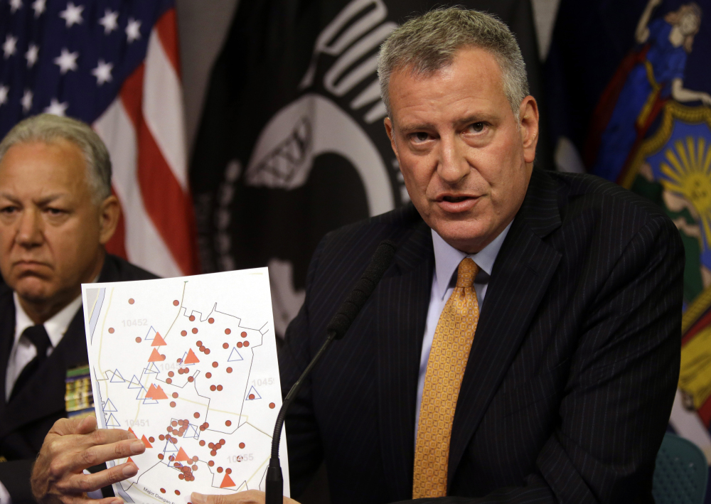 New York City Mayor Bill de Blasio holds a map showing the location in the Bronx borough of cooling towers, red triangles, and people, red dots, that were infected with Legionnaires’ disease.