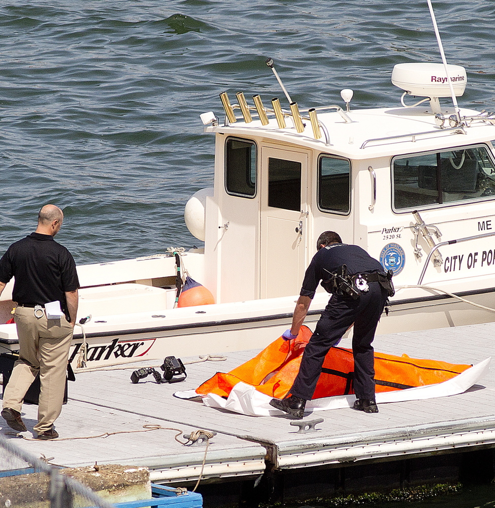 Portland police tend to a body that was recovered Monday from Portland Harbor near the Ocean Gateway terminal.