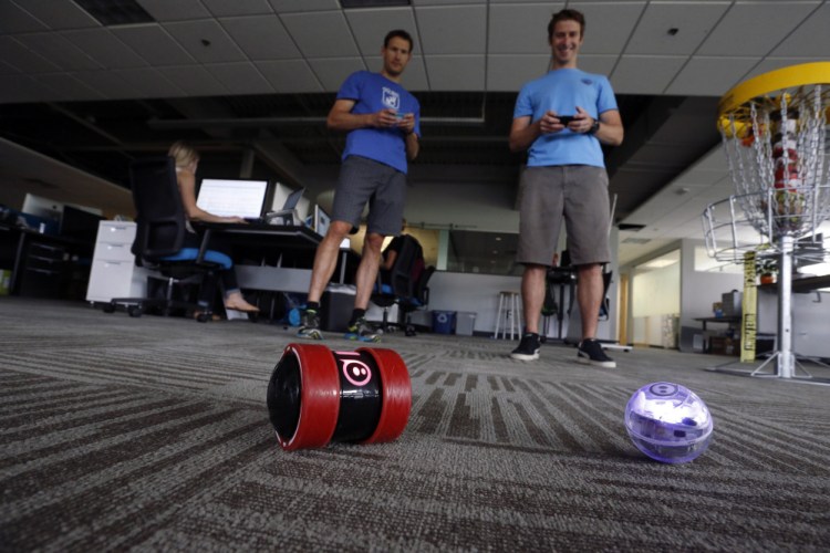 In this July 24, 2015 photo, project managers Bryan Rowe, right, and Bill Cullen, play with Sphero remote controlled toys at Sphero, a fast-growing toy robotics company, in Boulder, Colo.