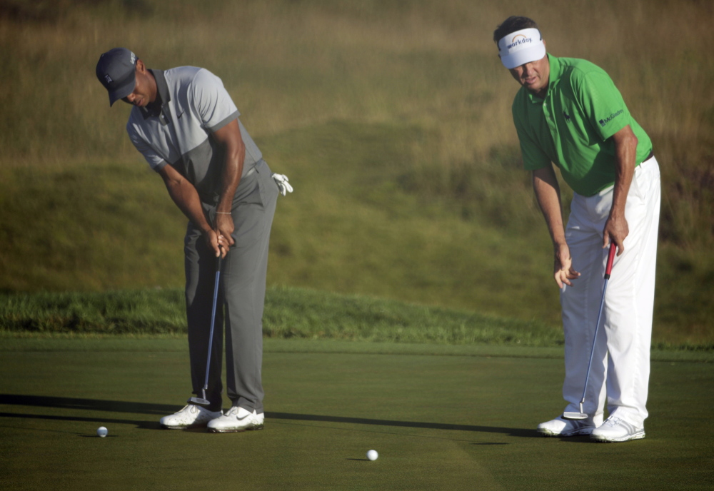 Tiger Woods, left, and Davis Love III practice putting Tuesday for the PGA Championship  at Haven, Wis. Woods’ winless streak in major tournaments is at 23, dating back to his winning the U.S Open in 2008.