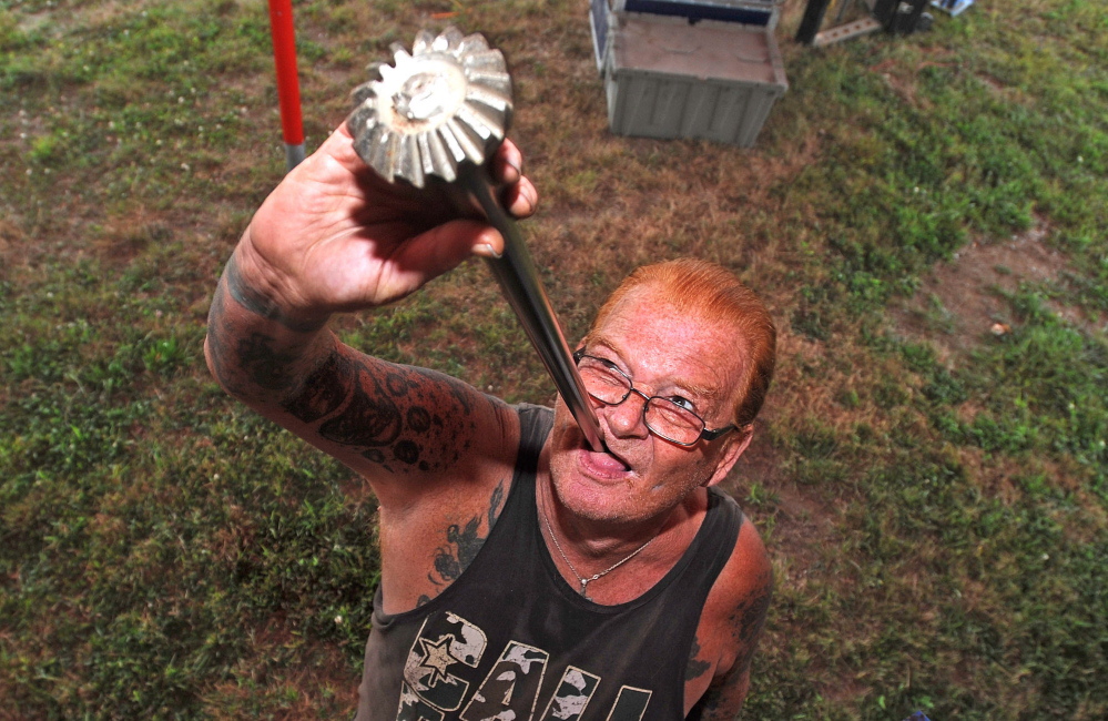 Sword swallower John “Red” Stuart swallows a car axle as he and his fellow performers with World of Wonders prepare for the annual Skowhegan State Fair at the Skowhegan Fairgrounds on Tuesday.