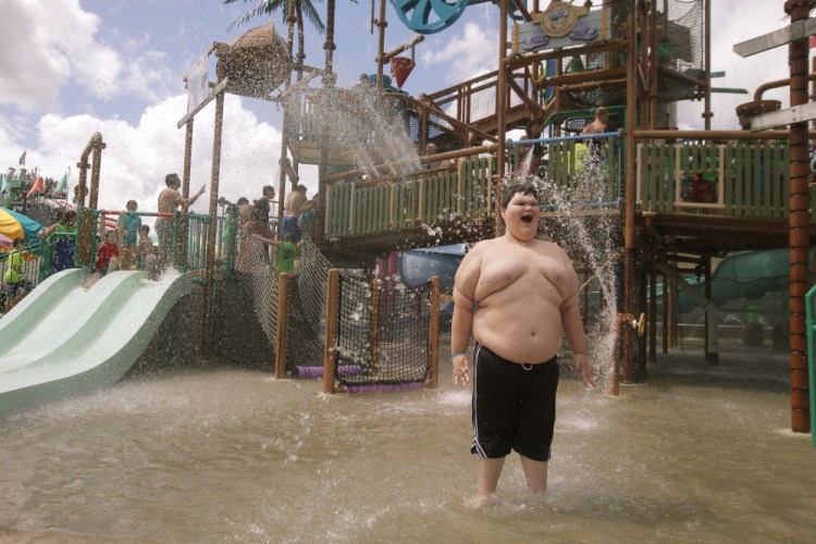 Dylan Dean, 11, smiles after being doused with water at Pirates Paradise at Splashtown in Saco on Wednesday. The Saco amusement park flew Dylan, who has Asperger’s syndrome and a condition that causes him to gain weight, and his family to Maine and gave them free passes to the park after they experienced an alleged bullying incident at a water park in their home state of Texas.