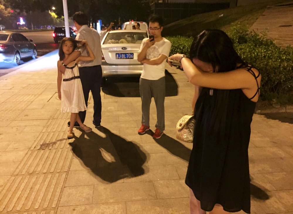 People react after a blast at Binhai new district, in Tianjin municipality, China, late Wednesday. The blast wave was felt several miles away, domestic media reported.
