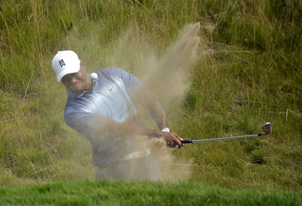 Tiger Woods hits out of a bunker on the 18th hole during the first round of the PGA Championship. He finished nine shots out of the lead, with a 75.