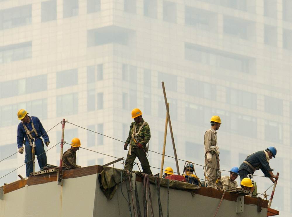 Laborers work during a smoggy day in Beijing. The lead author of a new study says 38 percent of the Chinese population lives in an area with a long-term air quality average that the U.S. Environmental Protection Agency calls “unhealthy.”