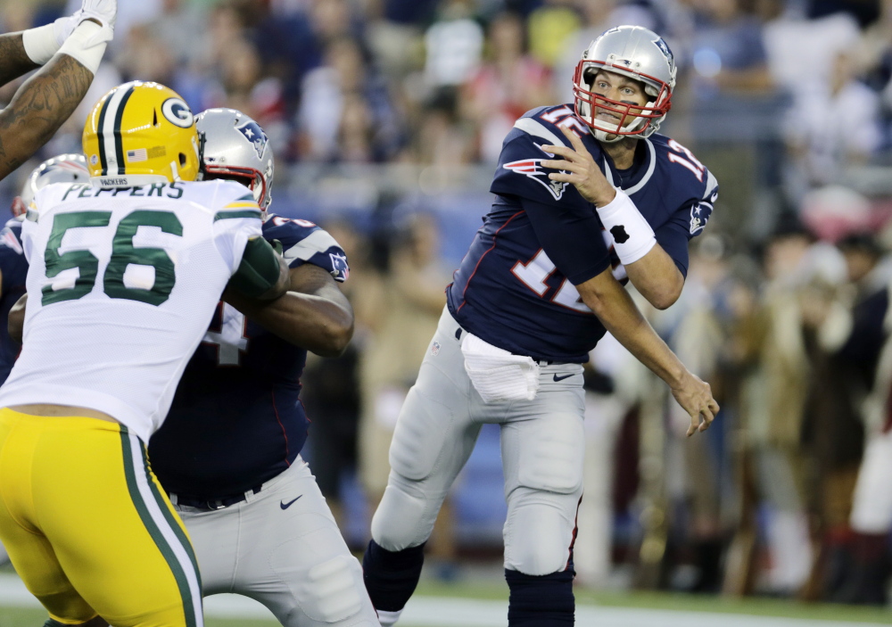 New England Patriots quarterback Tom Brady follows through on a pass over Green Bay Packers outside linebacker Julius Peppers in the first half of the Packers’ 22-11 preseason win Thursday in Foxborough, Mass.