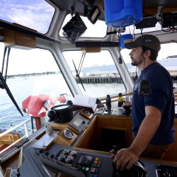 John Reeves, 29, captain of the tugboat Andrew McAllister, steers into Portland Harbor on his way to undock a ship. Portland Tugboat, part of New York-based McAllister Towing & Transportation, operates the port’s tugs. Derek Davis/Staff Photographer
