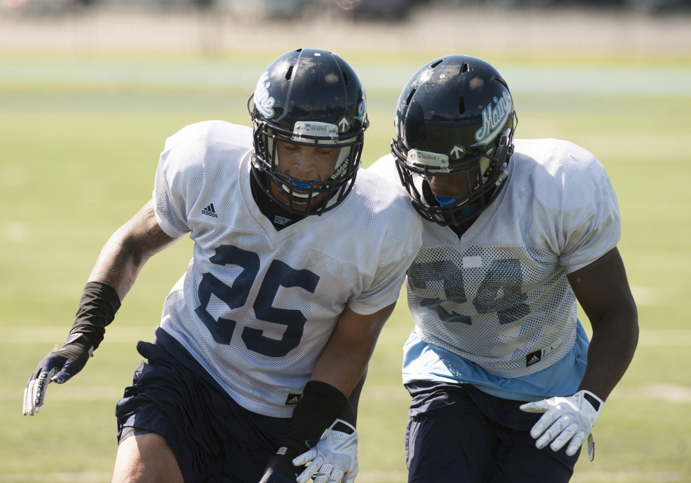 UMaine safeties Darrius Hart, left, and Sinmisola Demuren work out during practice Thurday in Orono. Maine should have a strong defense – it ranked second in the Colonial Athletic Association last season – but lacks experience at safety.  Kevin Bennett photo