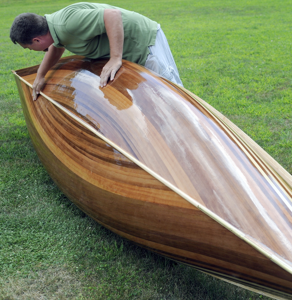 Math teacher Jeromy Jamison inspects the hull of the cedar-strip canoe he built with his Hall-Dale middle and high school students.