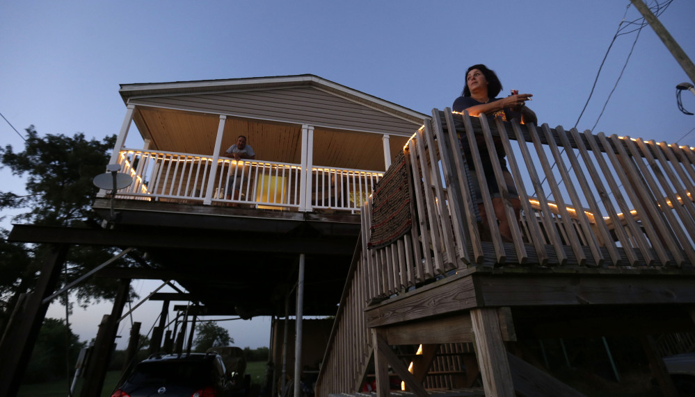Rocky Morales and Suzanne Guidroz stand outside their home – rebuilt after the previous one was destroyed by Hurricane Katrina – in Delacroix, La., last week. Hurricanes speed up the disappearance of land and Morales, one of the few remaining fisherman to still call Delacroix home, knows that another Katrina could be the end of his town.