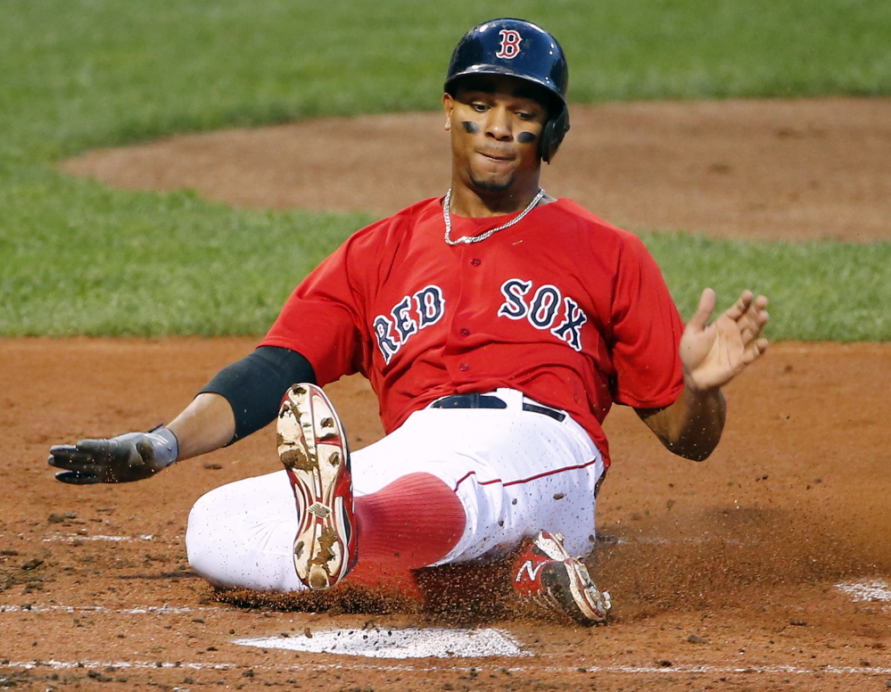 Boston’s Xander Bogaerts scores on an RBI double by David Ortiz during the first inning of the Red Sox’ 15-1 win over Seattle on Friday in Boston.