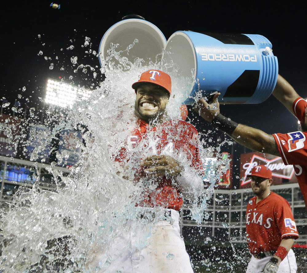 Delino DeShields of the Texas Rangers gets doused by teammate Rougned Odor after Texas beat the Tampa Bay Rays 5-3 Friday at Arlington, Texas.