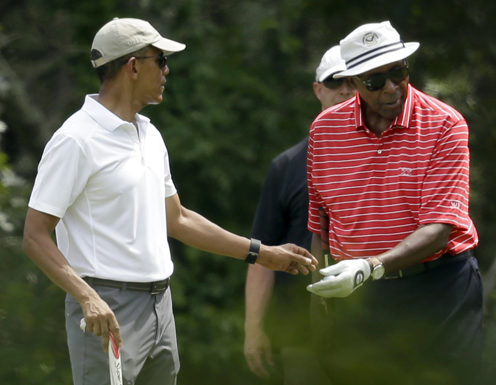 President Barack Obama  hands a ball to Vernon Jordan while golfing Saturday at Farm Neck Golf Club in Oak Bluffs, Mass., on the island of Martha’s Vineyard. 