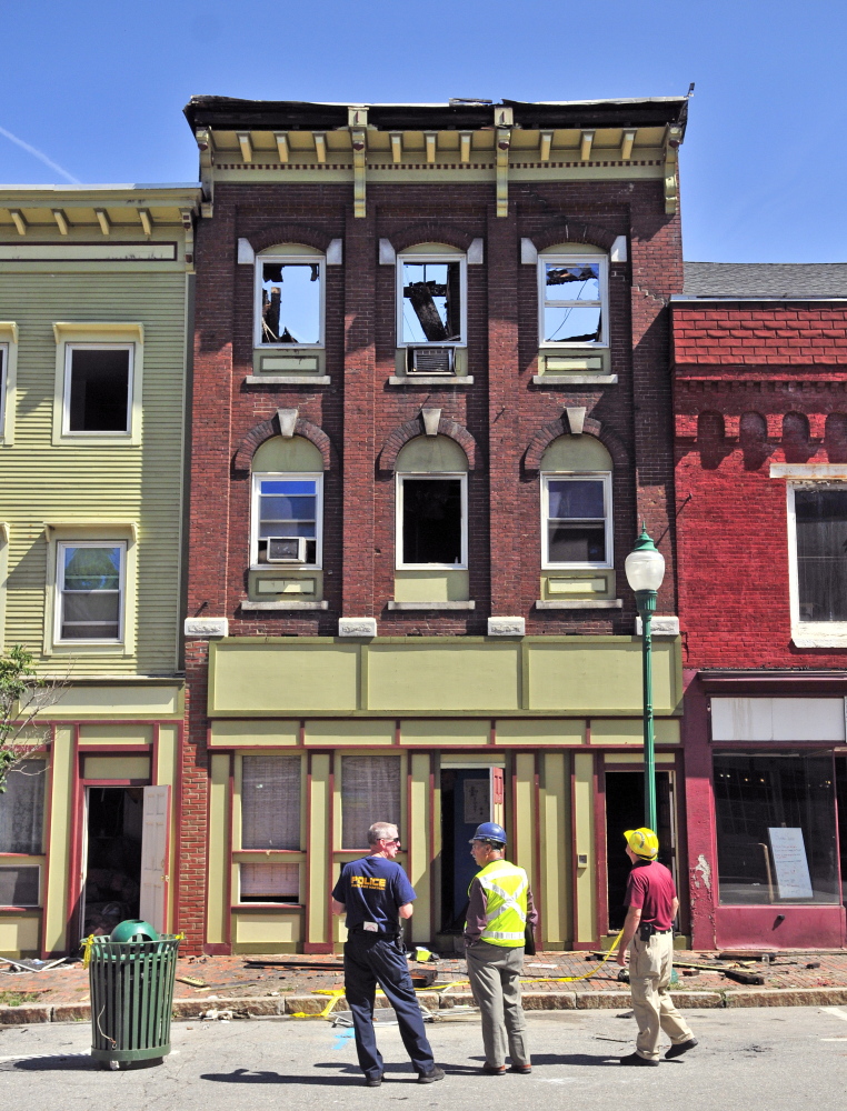 Officials stand in front of the scene the morning after the July 16 fire in downtown Gardiner.
