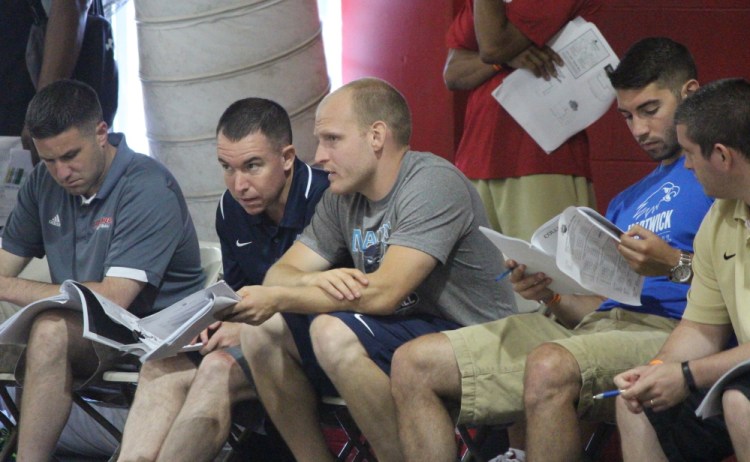 Bob Walsh, second from left, head coach of the men’s basketball team at the University of Maine, works with one of his assistant coaches, Zak Boisvert, scouting young athletes at last month’s Hoop Group Elite Camp in Reading, Pa.