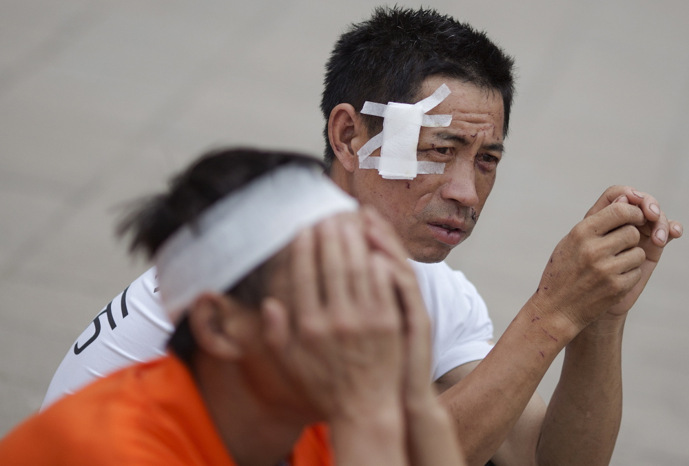 People injured in a huge explosion in Tianjin, China, pass the time at the school turned into a shelter for the evacuated. The blasts Wednesday night killed at least 112 people.