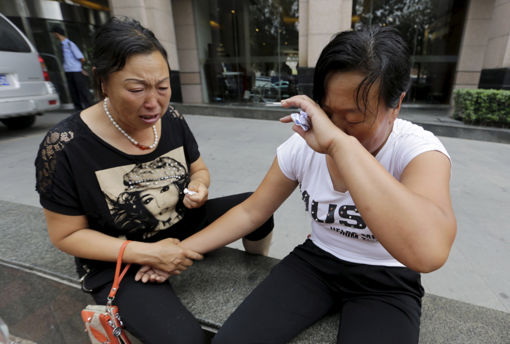 The mother of missing firefighter Dong Zepeng, right, wipes her face next to another family member as they cry outside the site of a news conference after demanding more information from government officials, following explosions Wednesday night in Tianjin, China. The death toll from two huge explosions that tore through an industrial area in Tianjin has risen to 112, the official Xinhua news agency said Sunday.