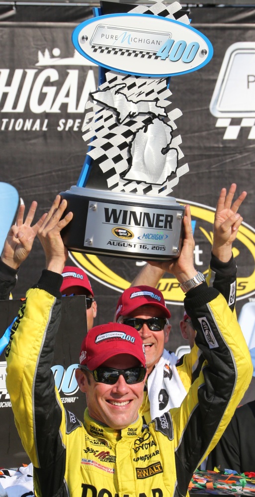 Matt Kenseth raises the winner’s trophy after a victory that gave Joe Gibbs Racing five wins in the last six Sprint Cup races.