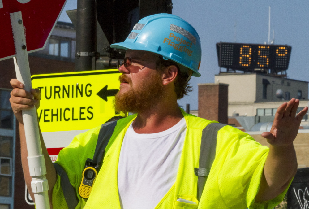 Construction flagger Michael Merrifield directs traffic at the intersection of High and Spring streets Monday, when temperatures hit a high of 89 in Portland. Ozone levels reached unhealthy levels for the first time in two years, state environmental officials said.