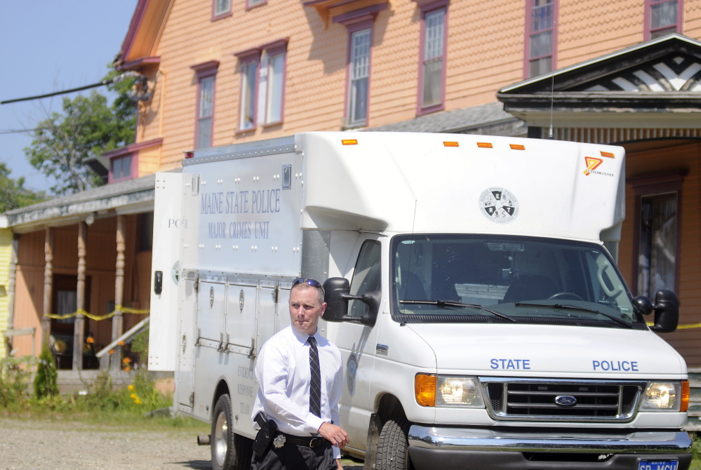 A Maine State Police detective walks out of the driveway of an East Pittston boarding home while investigating the fatal stabbing of the landlord in August.